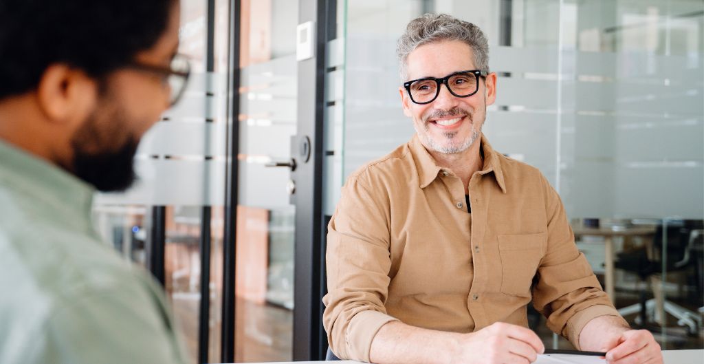 Company leader smiling at a colleague showing integrity